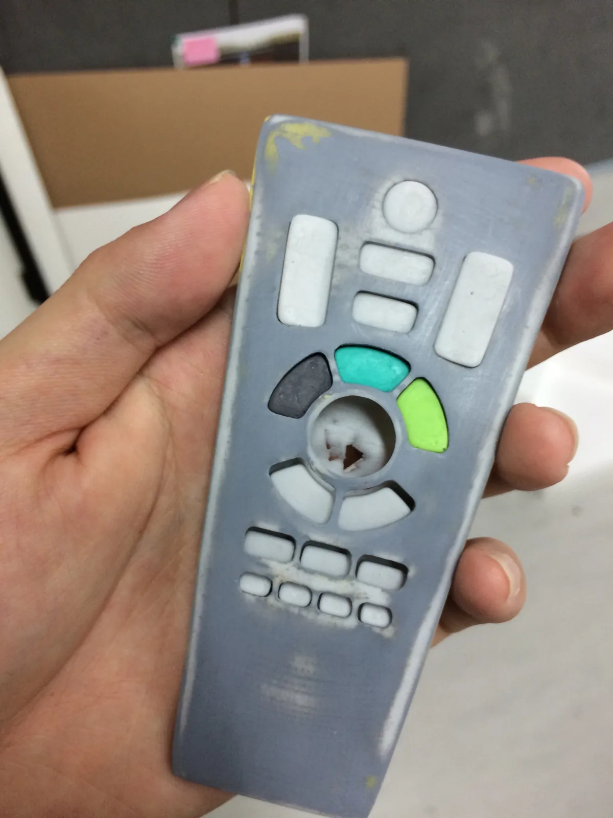Primed grey remote mock-up held in a hand